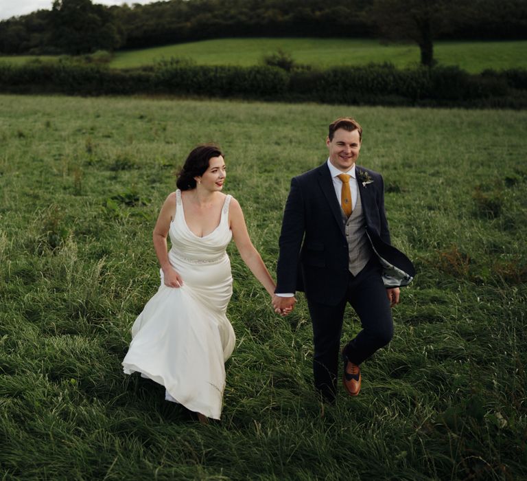 Bride & groom walk through countryside 