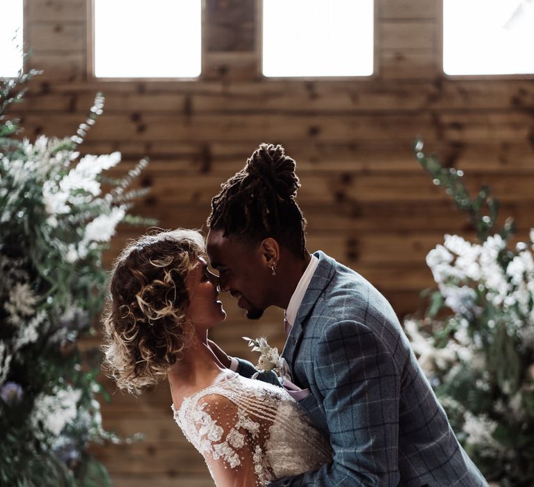 The groom dips his bride while they laugh