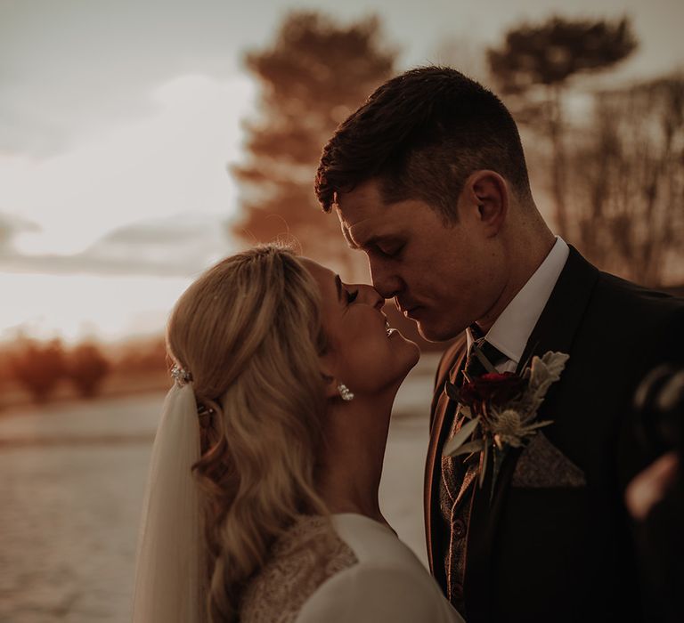 Bride and groom share a kiss at Eaves Hall wedding