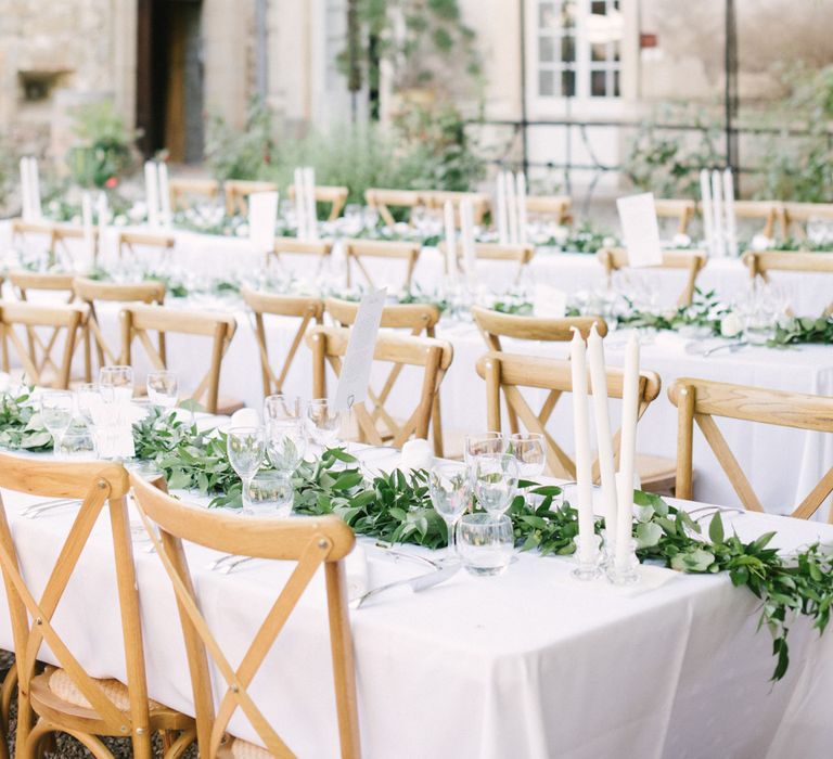 Outdoor wedding breakfast with long wooden tables and foliage table runners