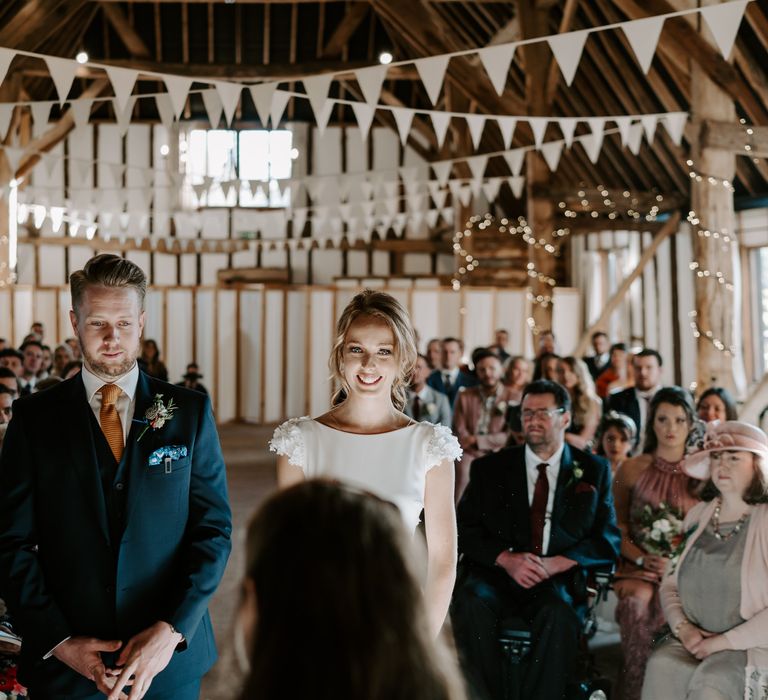 Clock Barn wedding ceremony with bunting and fairy light wedding decor 