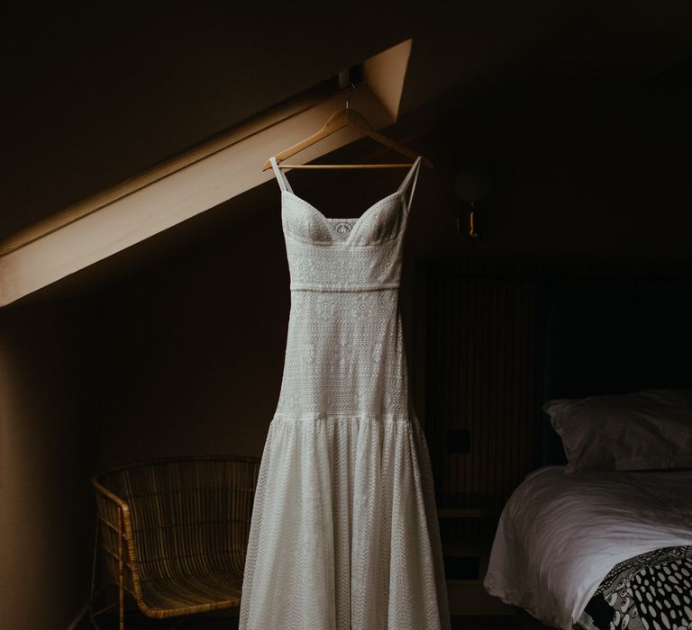 Boho lace white wedding dress hanging from velux window