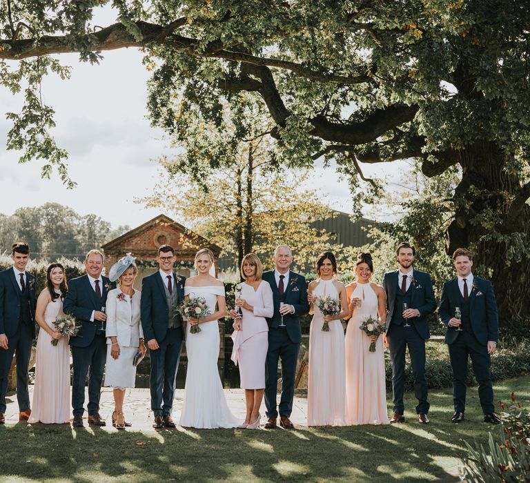 Wedding party stand together outdoors