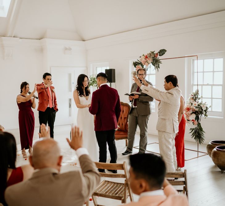 Intimate wedding ceremony with wedding guests blessing the couple 