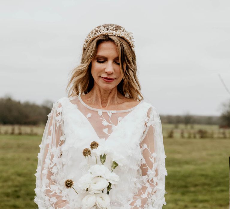 Bride in rustic luxe wedding outfit of bespoke embroidered bell sleeve wedding dress