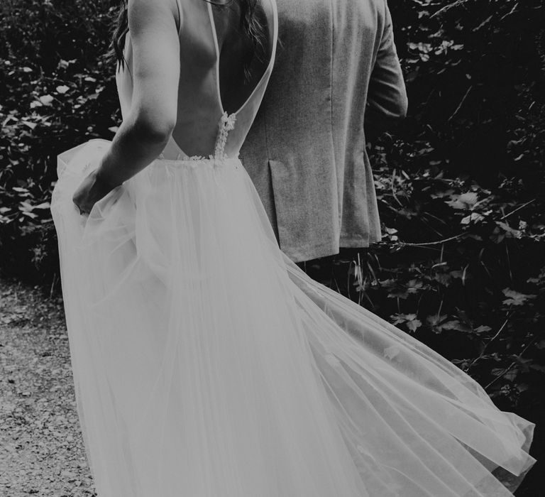 Bride lifts her skirt in black & white image