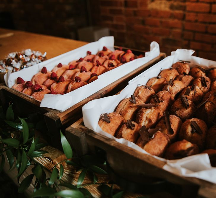 Doughnuts are displayed in wooden crates at an Indian British wedding. 