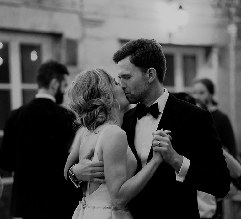 Romantic black and white portrait of the bride and groom kissing on the dance floor