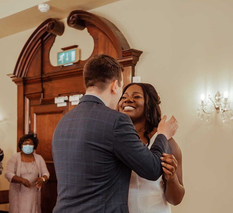 Bride & groom kiss on their wedding day as bride wears Whistles wedding gown