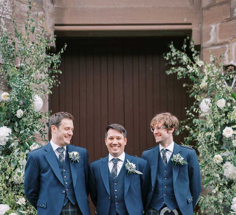 Groom and groomsmen in blue tartan kilts, sporrans and wool jackets at classic Castle wedding 