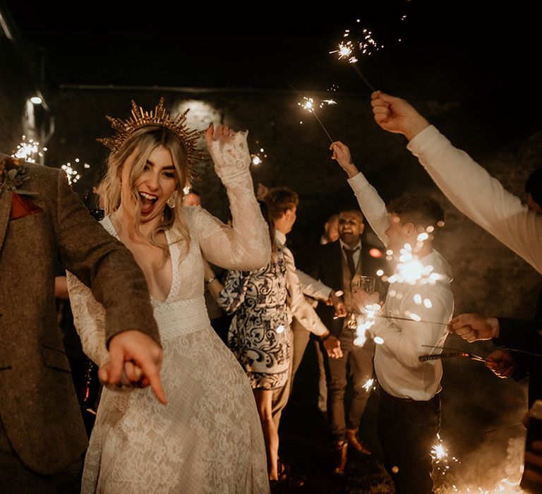 Fun sparkler moment at Lyde Court with groom in a wool suit and bride in a lace wedding dress and gown crown 