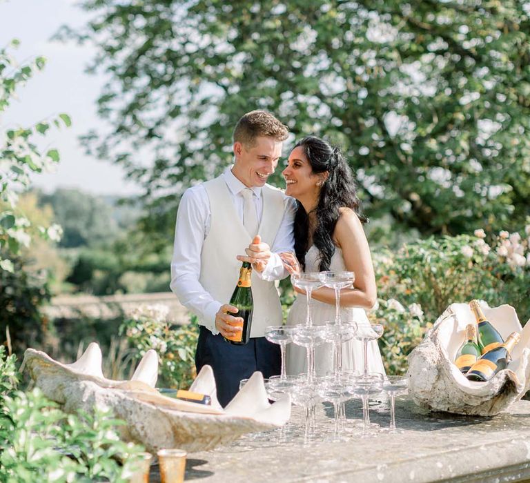 Bride & groom kiss in front of champagne tower 