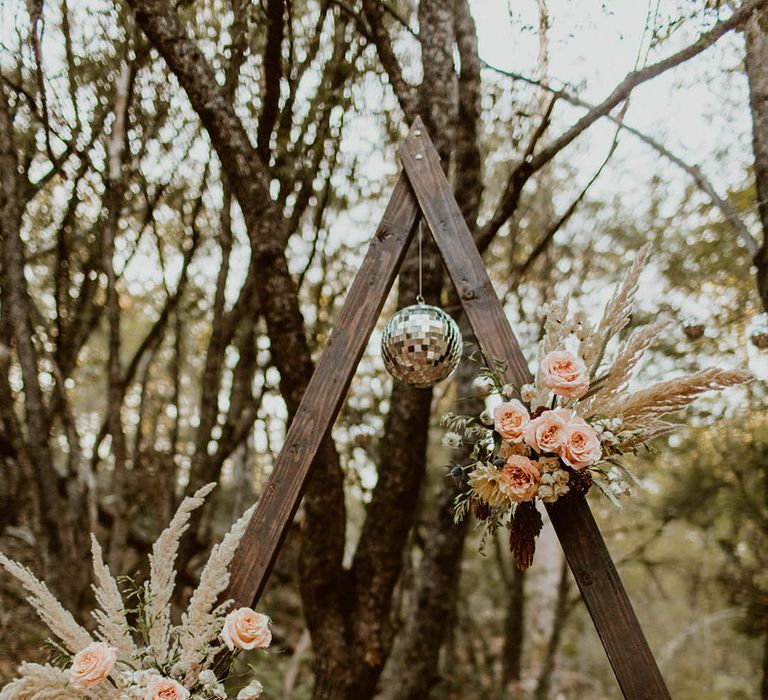 Disco ball hangs from wooden archway