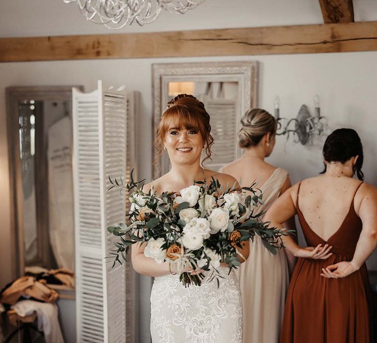 Bride with updo wears lace detailed Maggie Sottero wedding dress and open-toe mules 