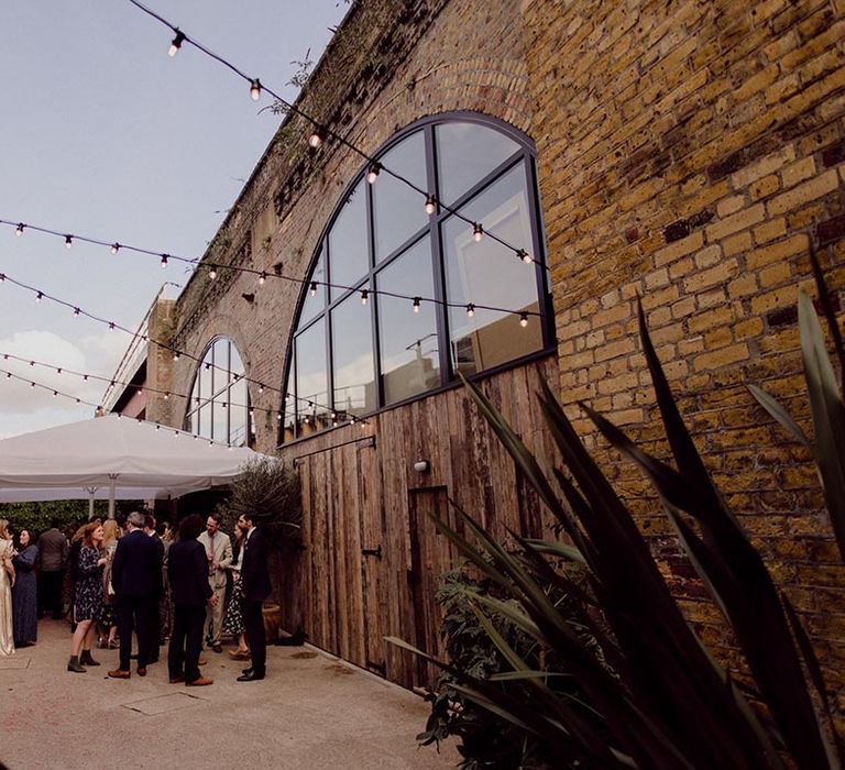 Wedding guests mingle outside the wedding venue, 100 Barrington in Brixton