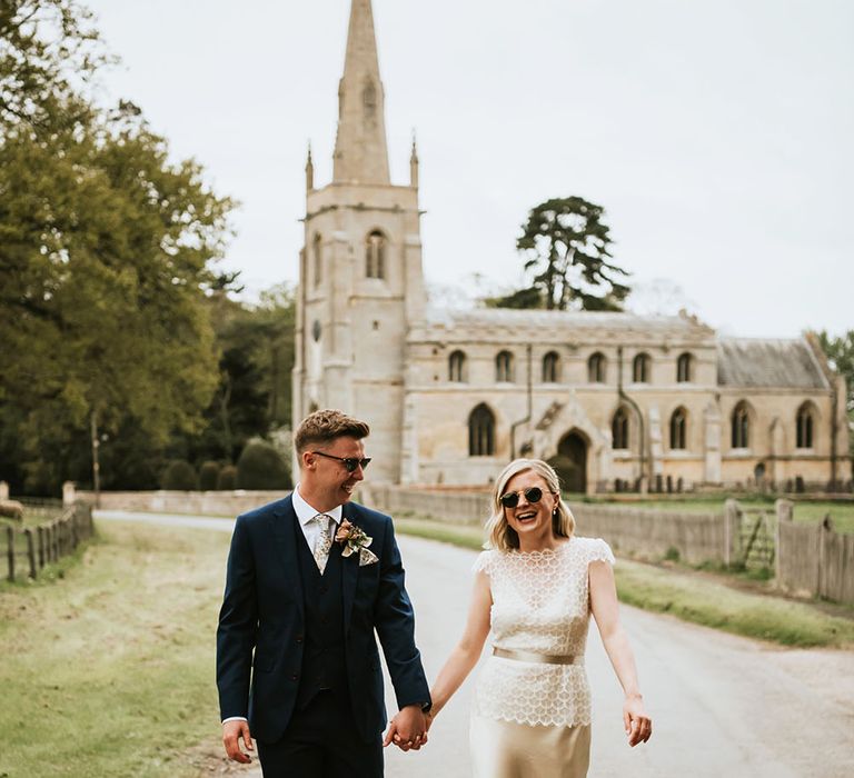 Bride wearing Kate Beaumont gold silk gown complete with eyelash lace cover and sunglasses 