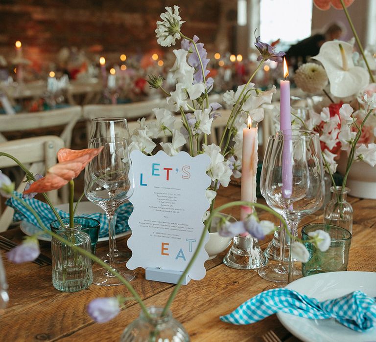 Pretty pastel tablescape with a wavy wedding menus and gingham patterned napkins