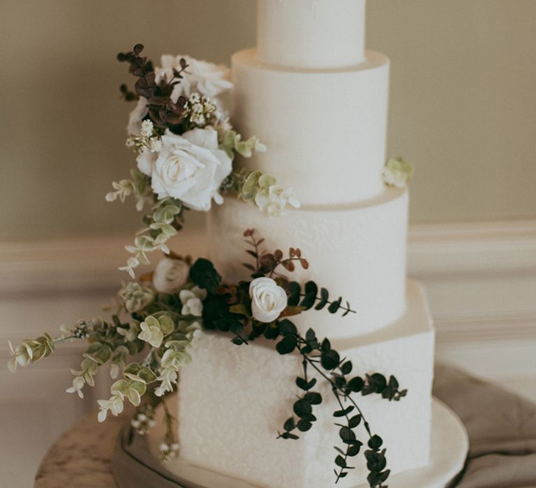 Four tier classic and traditional wedding cake with textured flower pattern 