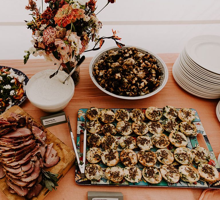 Wedding guests bring dishes to eat for buffet styled wedding breakfast 