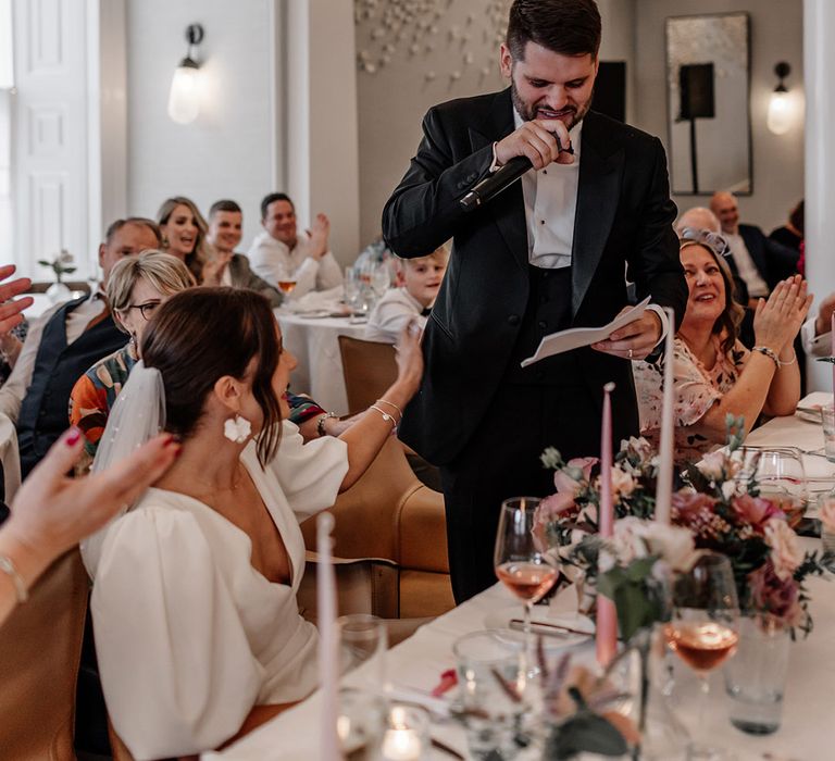 Groom in black suit giving speech at Somerset House wedding