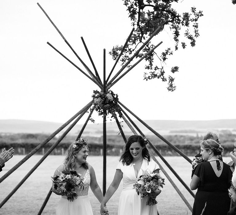 Brides start walking back down the aisle as a married couple with boho styling for the festival wedding 