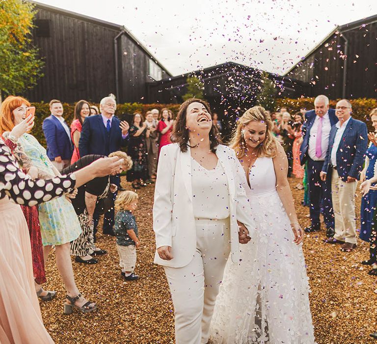 Win wedding photography with We Are // The Clarkes. This image showcases a colourful confetti shot at a lesbian wedding