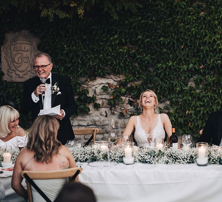 Babys breath table runner along white banquet tables outdoors 