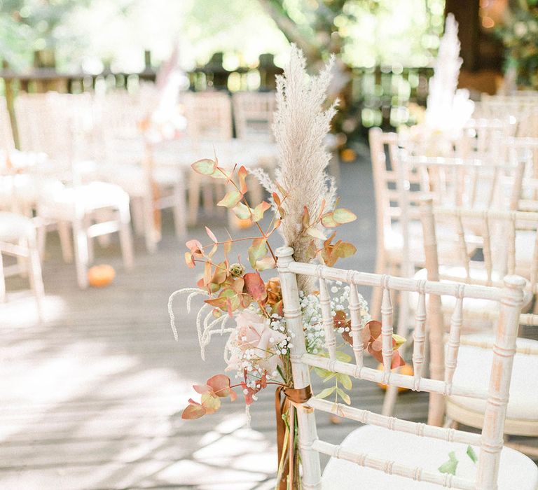 Autumnal pink rose, gypsophila, and pampas grass wedding flower chair decor for outdoor treehouse wedding 