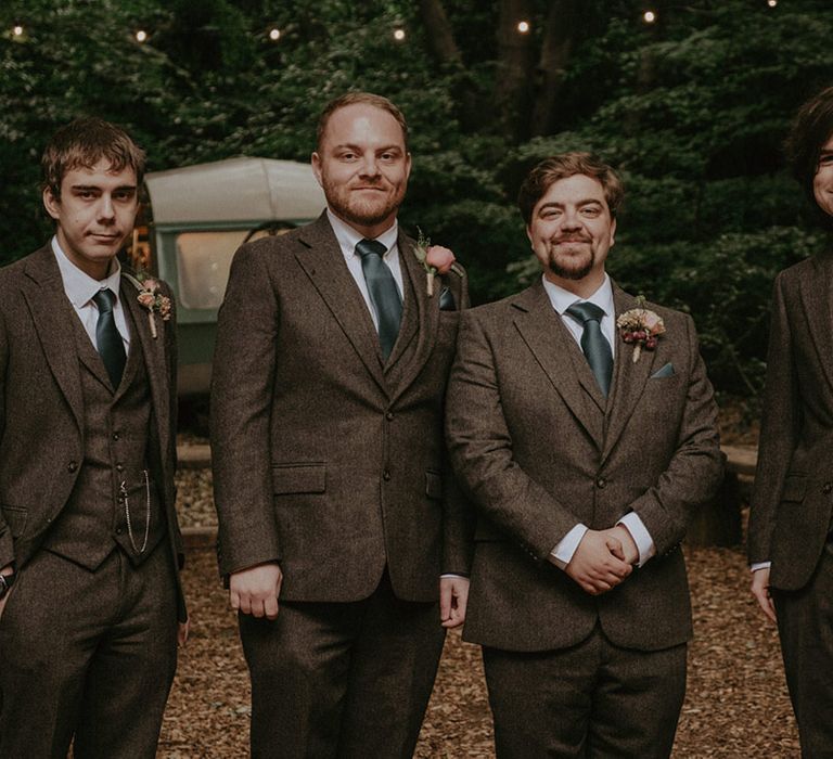 Groom and groomsmen in matching three piece tweed suit with dark green tie 