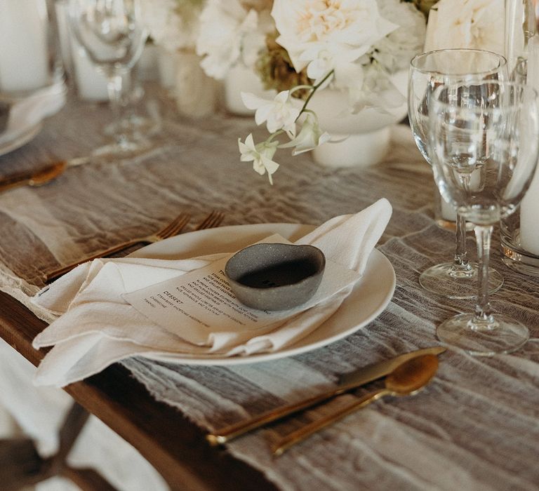 neutral colour palette wedding table decorations with ceramic ring holder name place settings and white wedding flowers 