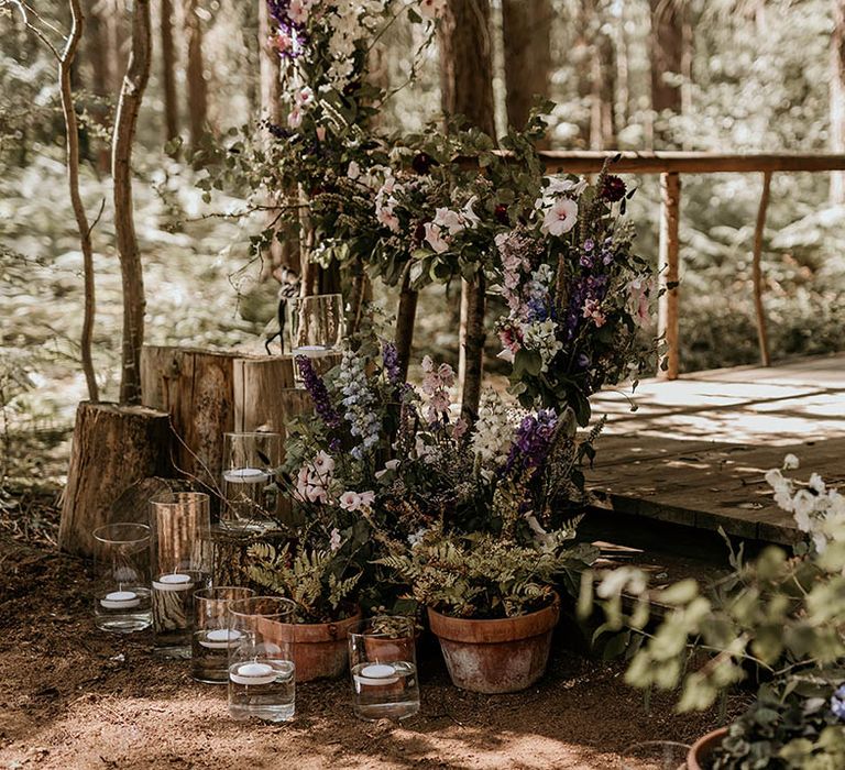 Purple wedding flower decorations with hurricane vases with tea lights decorating the gazebo at Camp Katur 