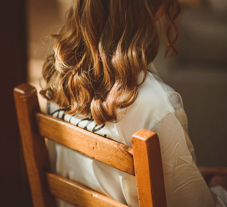 Bride with half up half down princess wedding hair style in satin bridal pyjamas 