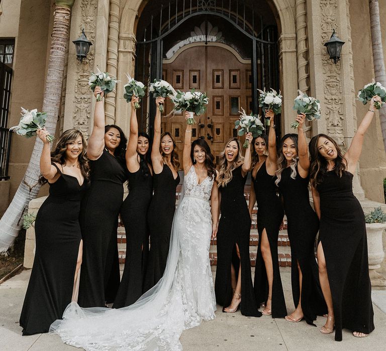 Bride in classic lace wedding dress with bridesmaids in black autumnal bridesmaid dresses 