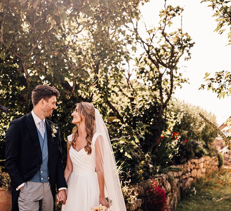 classic wedding with groom in a grey and black morning suit with blue waistcoat and bride in a Suzanne Neville princess wedding dress