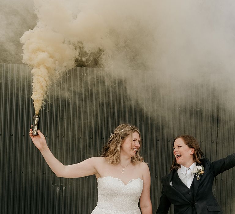 smoke bomb portrait at Stanford farm wedding with two brides in a strapless lace wedding dress and bridal suit 