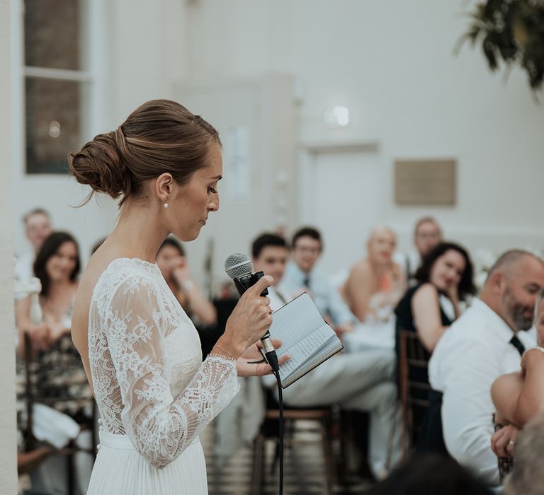 brides speech with long lace sleeves and chic bridal up do wedding hairstyle 