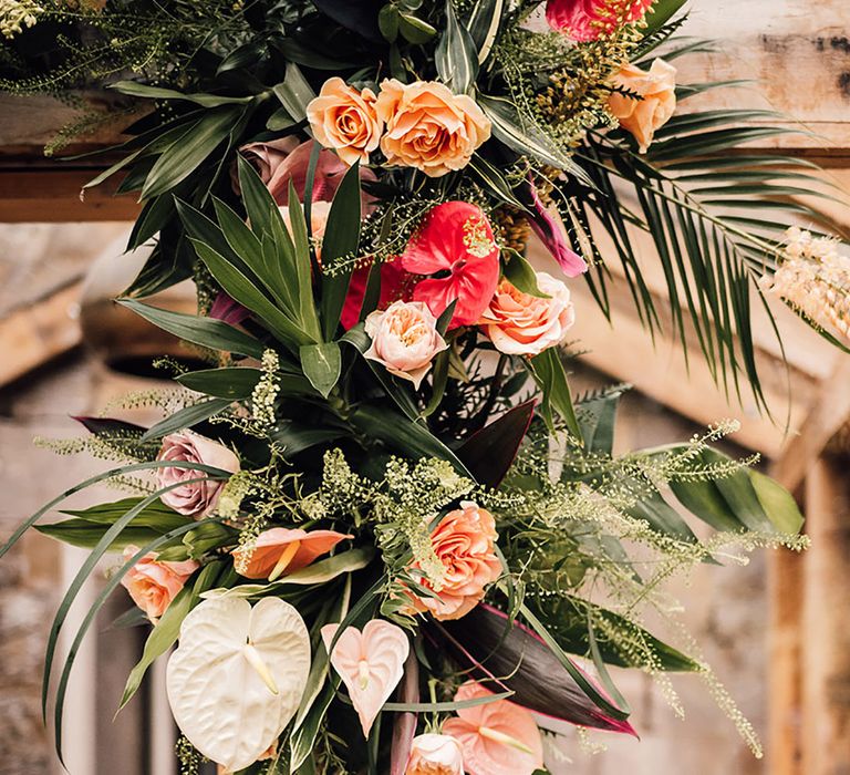 Anthuriums, roses, palm leaves and more in tropics red and orange wedding flower decorations 