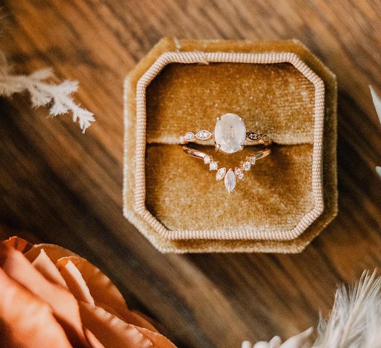 Wishbone shaped wedding ring and diamond engagement ring in yellow velvet ring box 