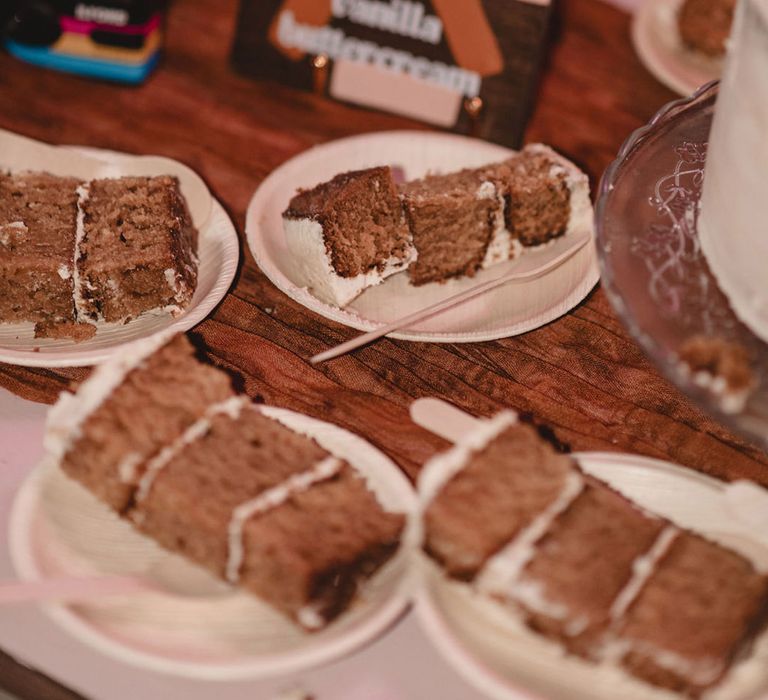 Slices of cake on paper plates for the wedding guests to eat 