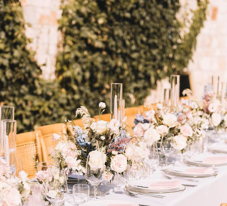 Boho pastel wedding theme with pastel pink candles and napkins and pastel floral centrepieces 