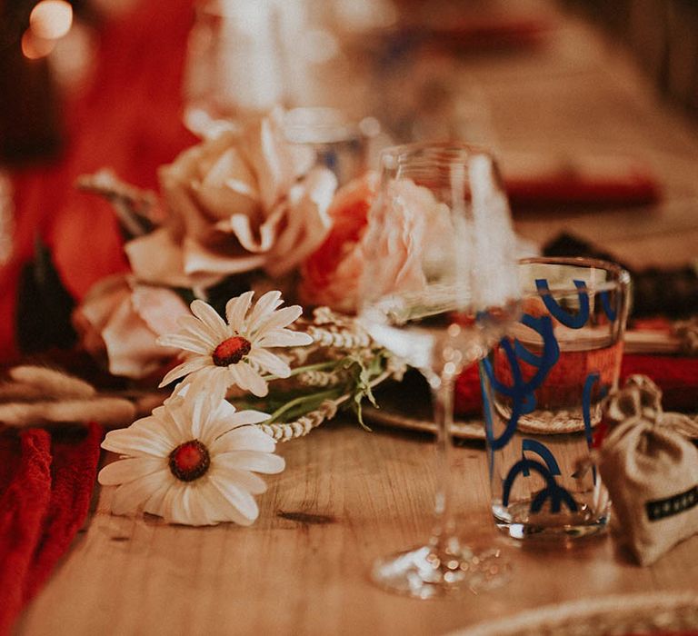 Wedding flowers on natural boho tablescape with red table runner 