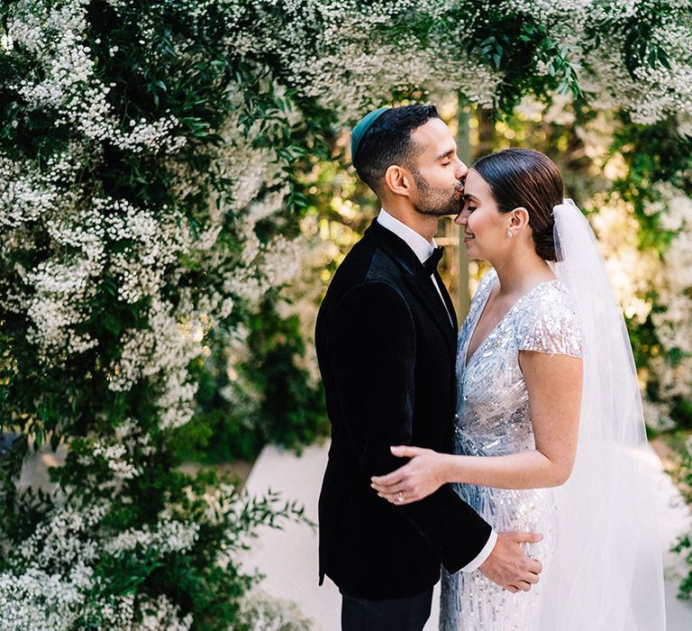 Groom in black tuxedo and yarmulke for Jewish wedding ceremony at Castello di Torcrescenza