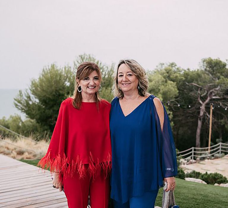 Wedding Guests Wearing Red and Blue Pant Suits at Stylish Outdoor Wedding at Masia Casa del Mar in Barcelona, Spain by Sara Lobla Photography