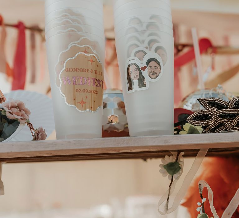 Personalised plastic tumblers for drinks at marquee wedding with the bride and groom's faces 