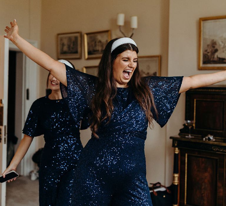 Bridesmaids Wearing Navy Blue Sequin Jumpsuits with Bell Sleeves & White Headbands