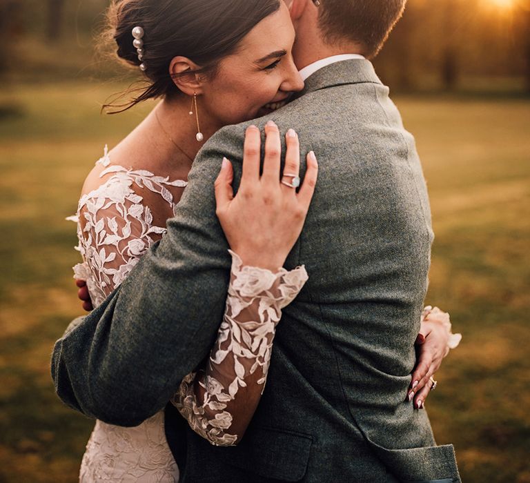 bride-in-floral-lace-wedding-dress-embracing-groom