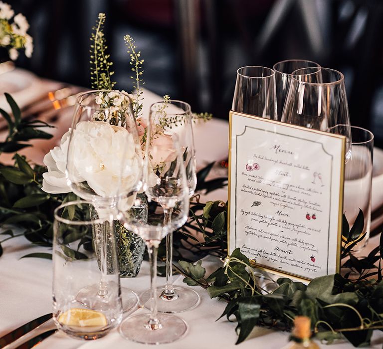 wedding-menu-sign-on-table-decorated-with-foliage-runner