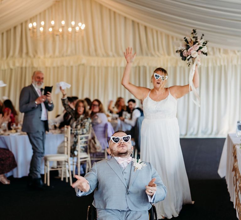 bride-and-groom-enter-wedding-reception-with-personalised-wedding-sunglasses