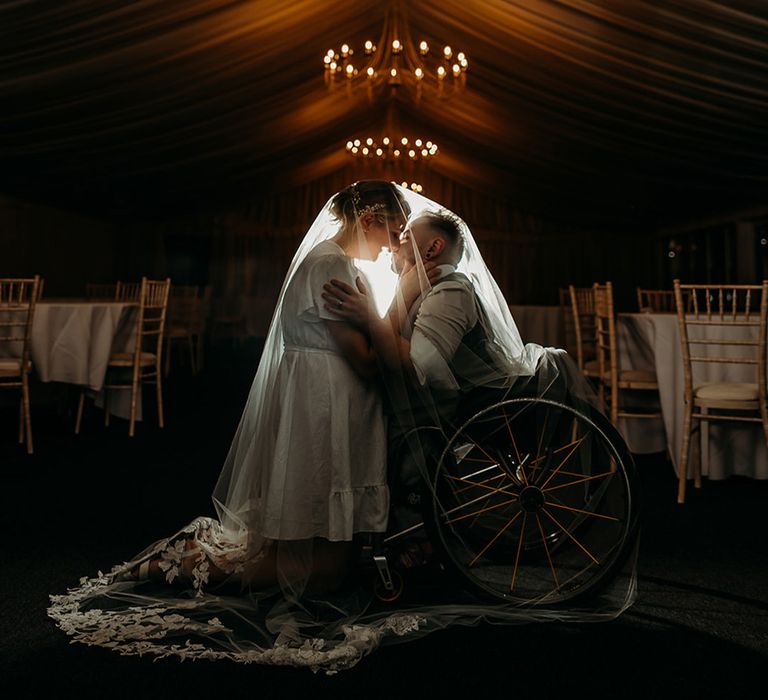 bride-and-groom-sit-under-embroidered-lace-wedding-veil