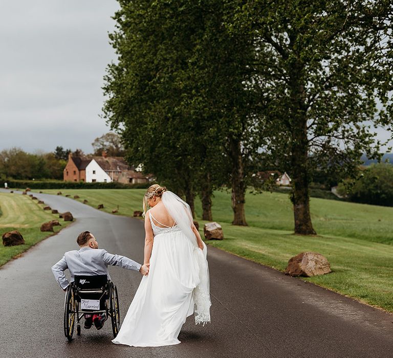 bride-holding-hands-with-groom-in-wheelchair-for-couple-portrait